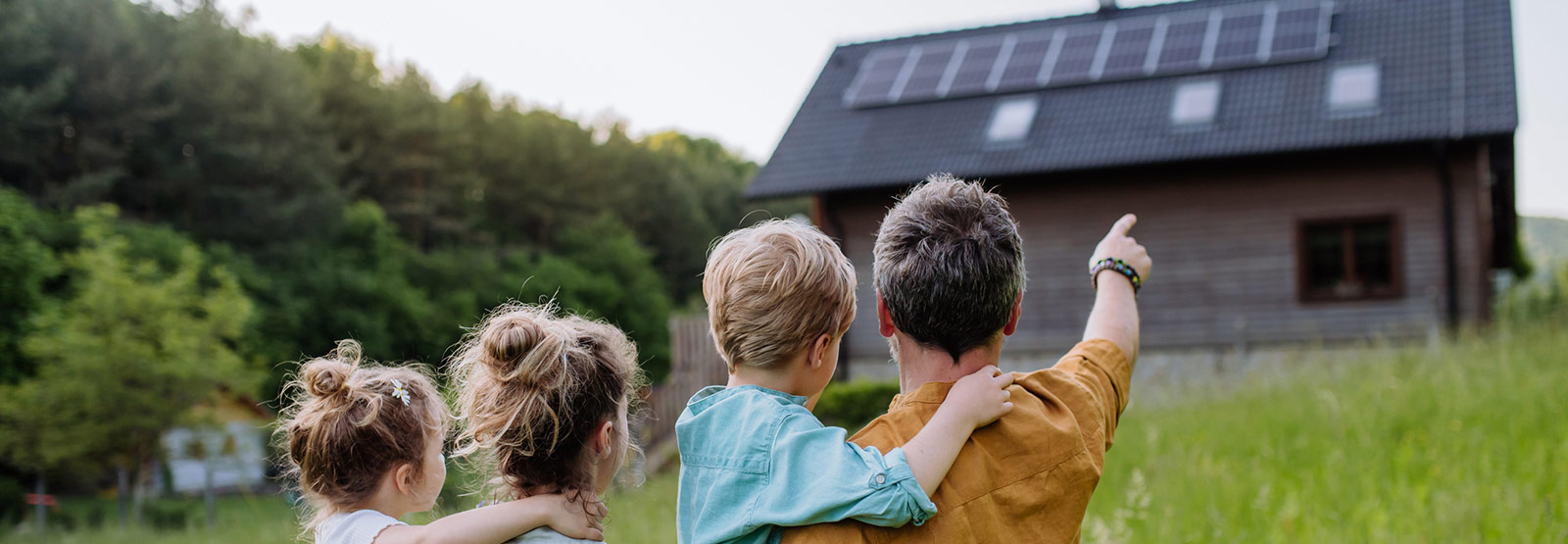 Family looking at the solar panels installed on their roof.