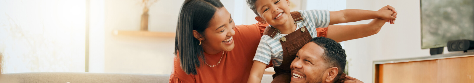 Family smiling in their living room.