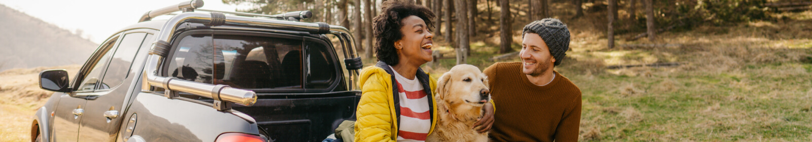 Couple and their dog preparing to hike.